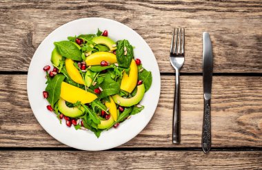 Arugula, ıspanak, dilimlenmiş mango ve avokado, nar ve ayçiçeği tohumu ile taze vegan salata