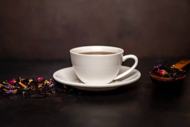 siyah arka plan üzerinde çiçek demlemek yığını ile taze çay fincan