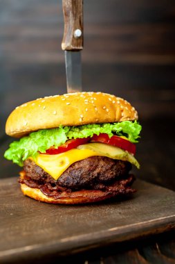 Ahşap arka planda bıçak yapışabilir taze ev yapımı Burger