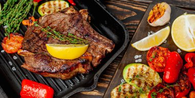 Taze ızgara biftek ahşap arka plan üzerinde sebze ile servis