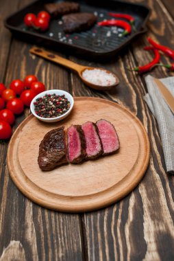 Taze ızgara dilimlenmiş biftek taze domates ve biber ahşap tahta üzerinde