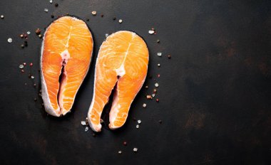 Siyah taş arka plan üzerinde baharat ile taze çiğ somon biftek