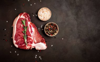 Biberiye dal, tuz ve biberiye siyah taş arka plan taze domuz biftek 