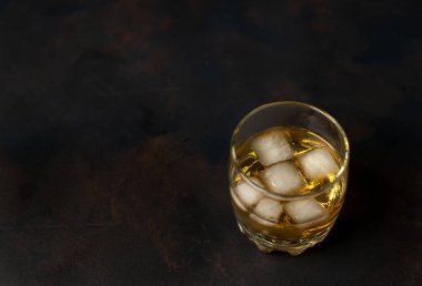 Siyah arka planda bir bardak buz viskisi
