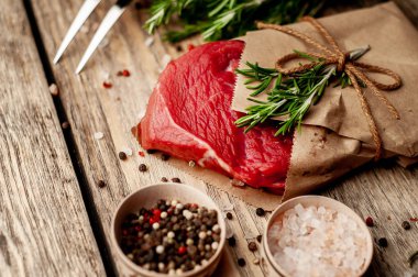 ahşap arka plan üzerinde zanaat kağıt sarılmış baharat ile biftek 