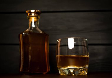 Siyah arka planda buz küpleri ve viski şişesi ile viski Bir bardak 