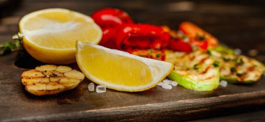 Ahşap tahtada ızgara sebze ve taze limonun yakın görünümü
