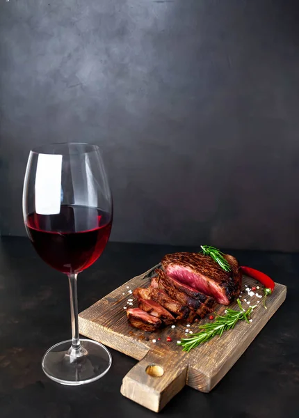 ahşap tahta üzerinde orta nadir sığır biftek kırmızı şarap cam ile servis