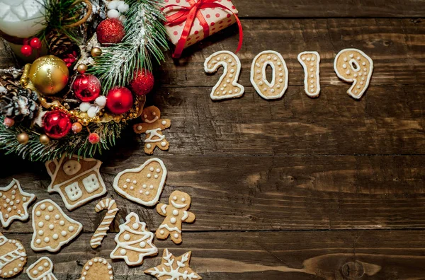 Ahşap arka plan üzerinde Noel hediye kutusu, köknar çelenk ve kurabiye 2019 