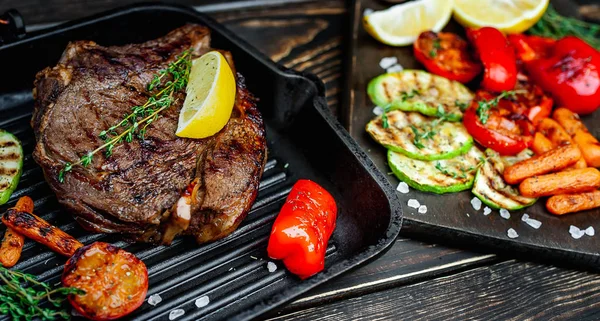 Izgara tavada ızgara sebzeler ile servis edilen taze ızgara biftek