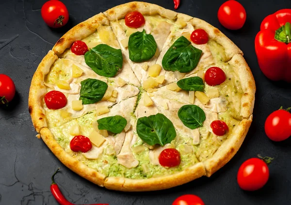 siyah taş arka plan üzerinde kiraz domates ve taze ıspanak yaprakları ile pizza