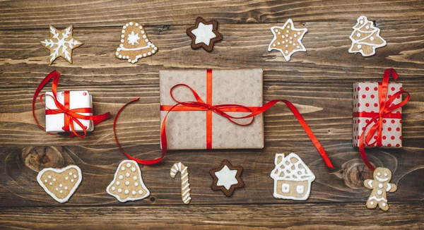 Collection of homemade christmas cookies with gifts on wooden background