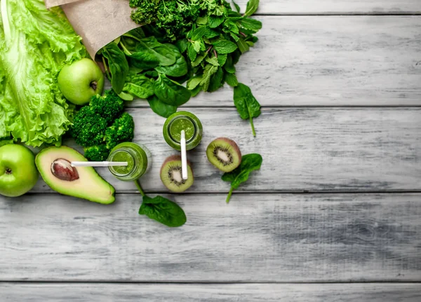 Gri arka planda sebze ve meyve ile Taze yeşil smoothie