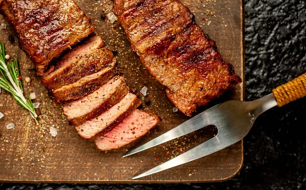 ahşap doğrama tahtası üzerinde baharat ve biberiye ile ızgara domuz biftek 