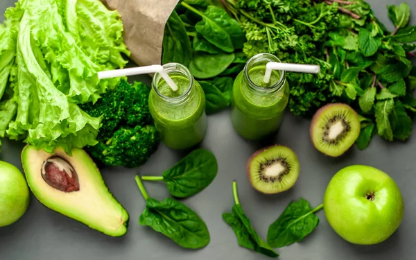 Gri arka planda sebze ve meyve ile Taze yeşil smoothie