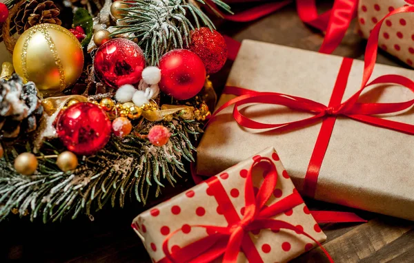 Eski ahşap arka plan üzerinde dekor ile kırmızı yay ve köknar çelenk ile hediye kutuları Yığını 