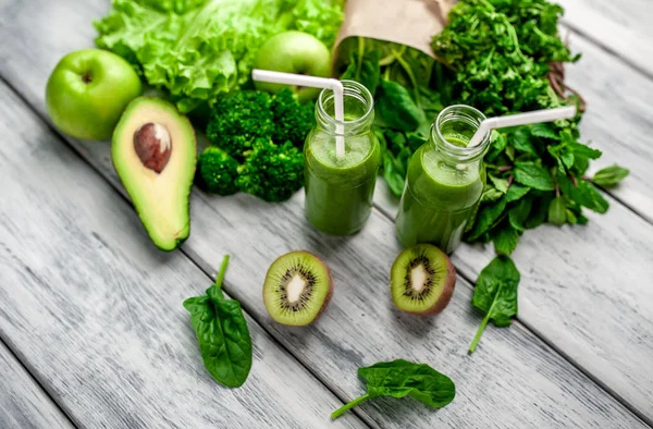 Gri arka planda sebze ve meyve ile Taze yeşil smoothie