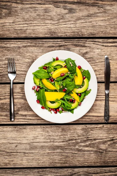 Arugula, ıspanak, dilimlenmiş mango ve avokado, nar ve ayçiçeği tohumu ile taze vegan salata
