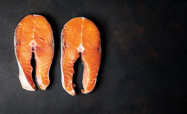Siyah taş arka plan üzerinde çift çiğ somon biftek