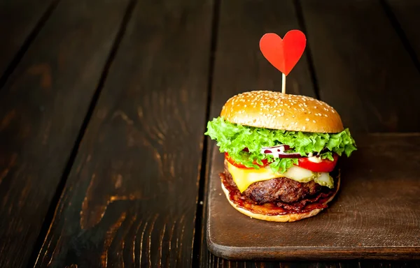 Świeży Domowy Burger Czerwonym Papierowym Sercem Ciemnym Drewnianym Tle — Zdjęcie stockowe