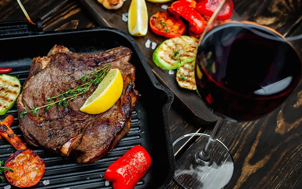 Izgara tavada ızgara sebzeler ile servis edilen taze ızgara biftek