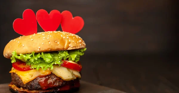 Świeży Domowy Burger Czerwonymi Papierowymi Sercami Ciemnym Drewnianym Tle — Zdjęcie stockowe