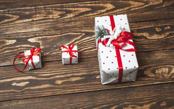 Pile of gift boxes with red bows on old wooden background