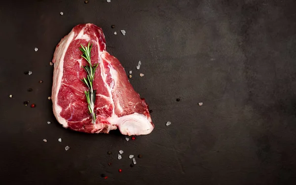 Čerstvý Vepřový Steak Rozmarovou Větvikou Solí Pepřem Černém Kamenném Pozadí — Stock fotografie