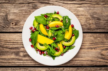 Arugula, ıspanak, dilimlenmiş mango ve avokado, nar ve ayçiçeği tohumu ile taze vegan salata