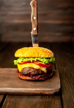 Ahşap arka planda bıçak yapışabilir taze ev yapımı Burger