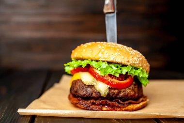 Ahşap arka planda bıçak yapışabilir taze ev yapımı Burger