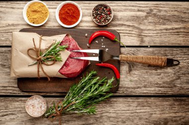 Ahşap arka planda baharatlar ile Çiğ taze biftek