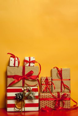Parlak sarı arka plan üzerinde kırmızı yaylı hediye kutuları yığını 