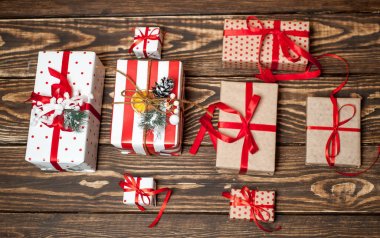 Eski ahşap arka plan üzerinde kırmızı yayile hediye kutuları yığını 