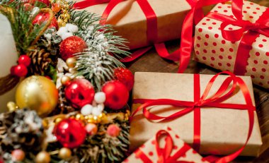 Eski ahşap arka plan üzerinde dekor ile kırmızı yay ve köknar çelenk ile hediye kutuları Yığını 