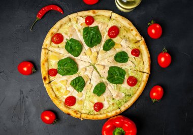 siyah taş arka plan üzerinde kiraz domates ve taze ıspanak yaprakları ile pizza