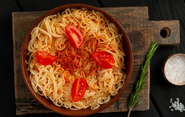 ahşap doğrama tahtası üzerinde domates sosu ve biberiye ile İtalyan spagetti makarna 