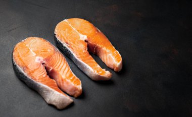 Siyah taş arka plan üzerinde çift çiğ somon biftek