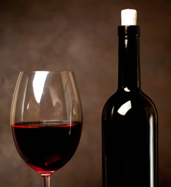 Siyah arka planda kırmızı şarap ve şarap şişesi bir bardak