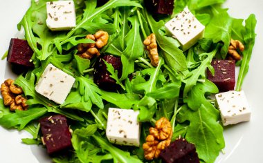 Arugula ve ıspanak ile taze salata, dilimlenmiş pancar, beyaz peynir ve ceviz