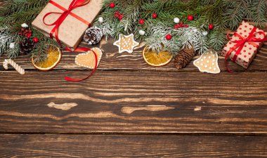 Ahşap arka plan üzerinde hediye kutuları, köknar dalları ve kurabiye ile Noel kompozisyon