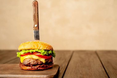 Ahşap arka planda bıçak yapışabilir taze ev yapımı Burger