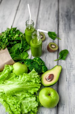 Gri arka planda sebze ve meyve ile Taze yeşil smoothie