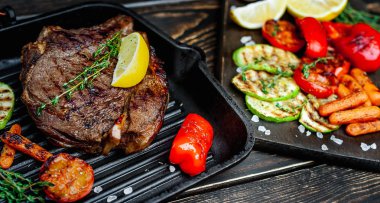 Taze ızgara biftek ahşap arka plan üzerinde sebze ile servis