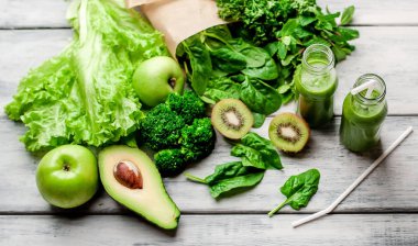 Gri arka planda sebze ve meyve ile Taze yeşil smoothie