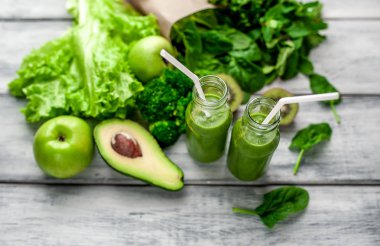 Gri arka planda sebze ve meyve ile Taze yeşil smoothie