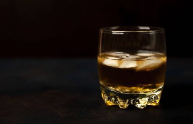 Siyah arka planda bir bardak buz viskisi