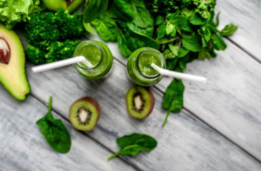 Gri arka planda sebze ve meyve ile Taze yeşil smoothie