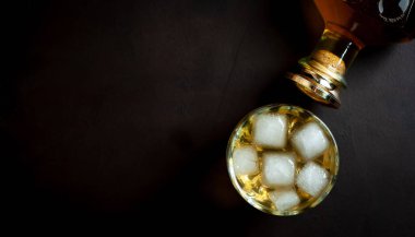 Siyah arka planda buz küpleri ve viski şişesi ile viski Bir bardak 