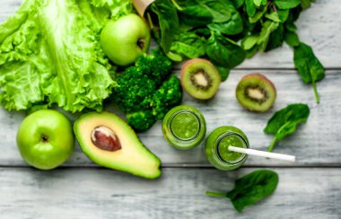 Gri arka planda sebze ve meyve ile Taze yeşil smoothie